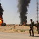 Smoke rises from the Bai Hassan oil station on July 31, 2016, following an ISIL attack. A month later, ISIL blew up a Bai Hassan oil well, and continued to attack oil infrastructure in the area throughout 2017, according to PAX.
